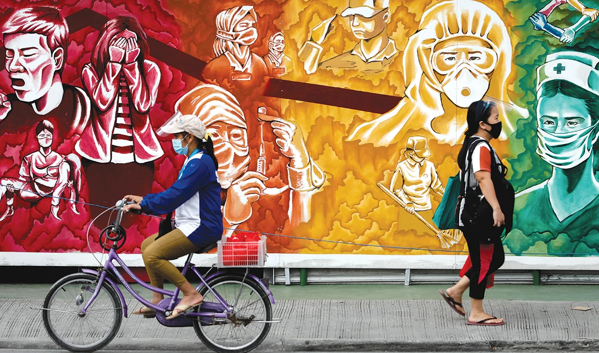 Filipinos wearing masks for protection against coronavirus disease (COVID-19) pass a mural dedicated to healthcare workers in this Oct. 30, 2020 photo taken in Manila. (Reuters)