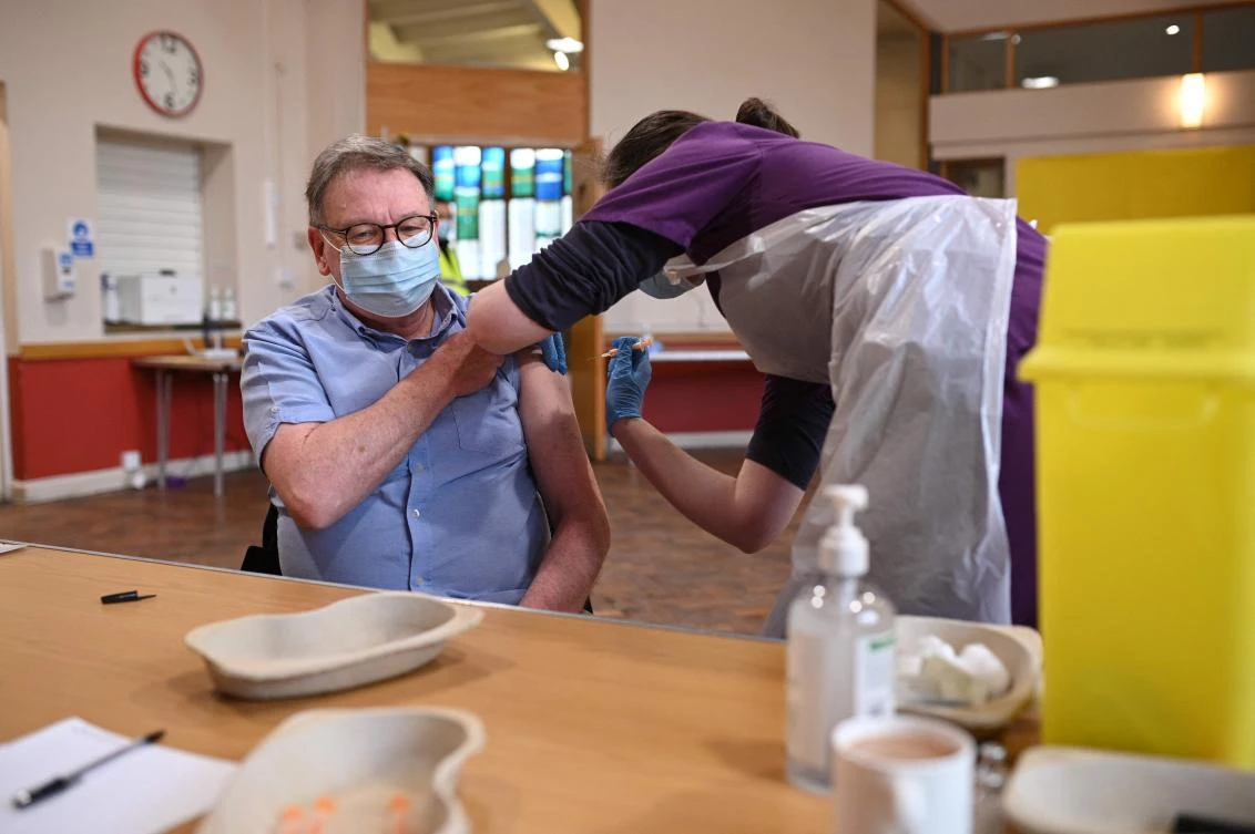 Doctor Kate Martin (R) administers an injection of AstraZeneca/Oxford Covid-19 vaccine to a patient at the vaccination centre set up at St Columba's church in Sheffield, northern England, on February 20, 2021. (AFP)
