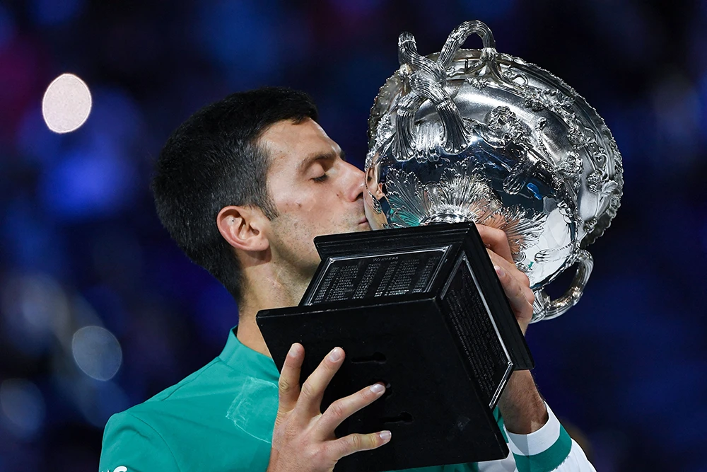 Serbia's Novak Djokovic kisses the Norman Brookes Challenge Cup trophy following his victory against Russia's Daniil Medvedev during the Australian Open tennis tournament in Melbourne on February 21, 2021. (AFP)
