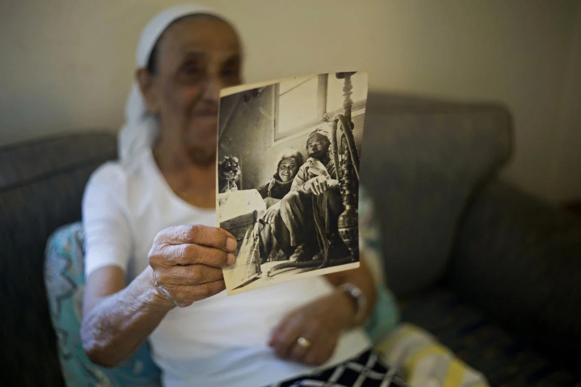 Yemen born Jewish Israeli Yona Josef, who lost a sister, holds a photograph dated back to the 1940’s of her and her father back in Yemen in her home in Raanana, Israel, July 11, 2016. (AP Photo)