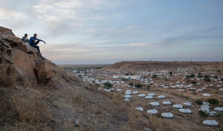 Tigray men sit atop a hill overlooking part of the Umm Rakouba refugee camp, hosting people who fled the conflict in the Tigray region of Ethiopia, in Qadarif, eastern Sudan. (AP)