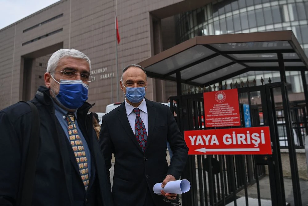 Pilot Noyan Pasin (R) and his lawyer Erem Yucel walk by the Bakirkoy courthouse in Istanbul, on Feb. 24, 2021, after a verdict trial against seven individuals accused of smuggling former Nissan chairman Carlos Ghosn out of Japan. (AFP)