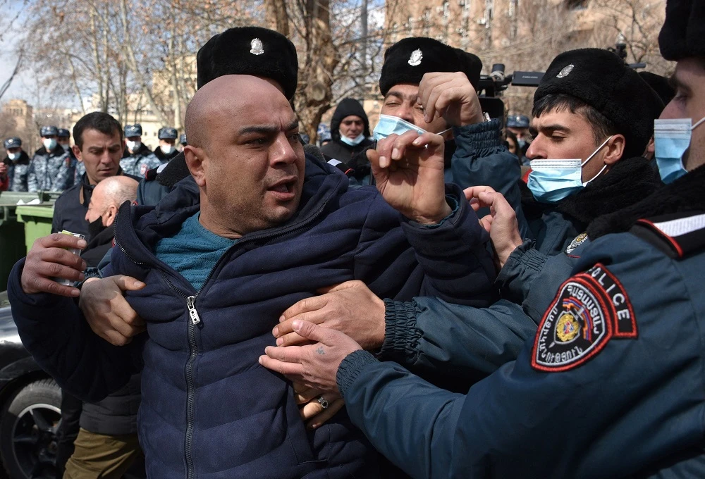 Armenian police officers detain a supporter of opposition Dashnaktsutyun party during a rally to demand the resignation of prime minister Nikol Pashinyan on Feb. 23, 2021. (AFP)
