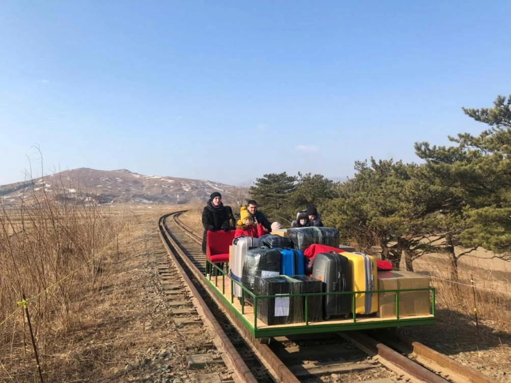 Russian diplomats and family members use a hand-pushed rail trolley to leave North Korea amid the coronavirus disease (COVID-19) restrictions while crossing the demarcation line between North Korea and Russia, February 25, 2021. Picture taken February 25, 2021. (AP)