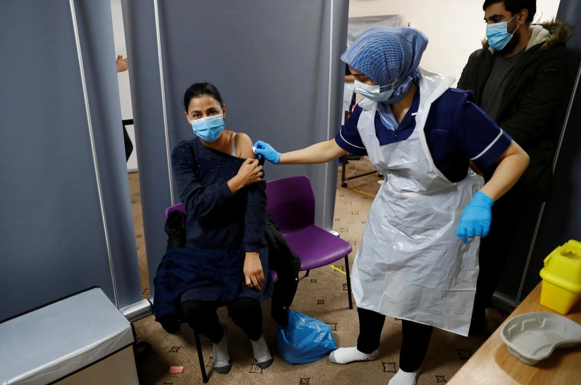 Abida Bi receives a coronavirus disease (COVID-19) vaccine from nurse Zenub Mahood, at Bradford Central Mosque in Bradford, Britain, February 25, 2021. (Reuters)