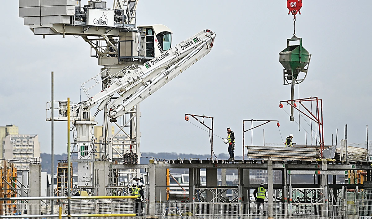Construction workers work to build new apartments and a retail complex at Nine Elms in south London, as building sites remain open during the national lockdown to combat the pandemic. (AFP)