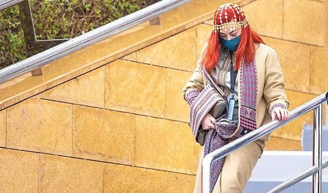 In this undated photo, Brandi Janow, a Saudi American, wears a gold coin headpiece and a farwa (heavy overcoat) featuring a Sadu piece, or traditional embroidery of the region, on her coat lapels in Saudi Arabia. (Supplied)