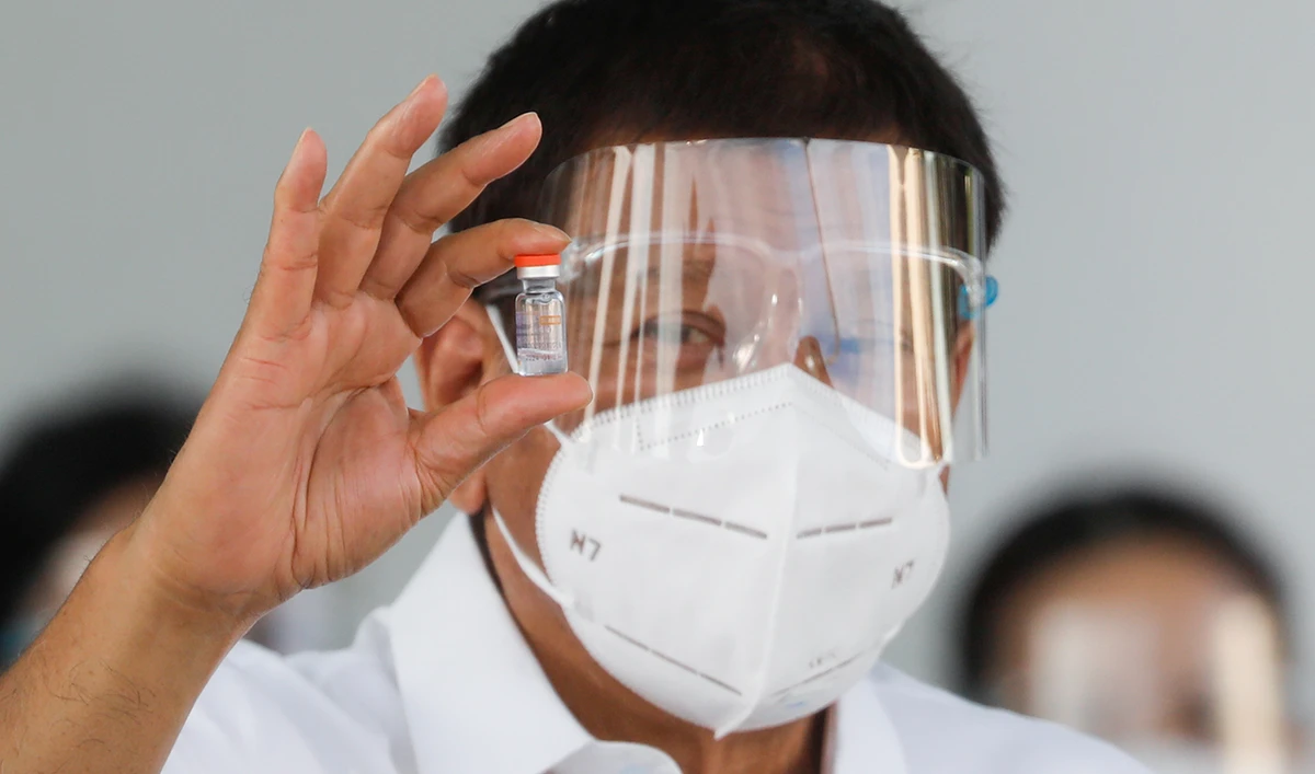 Philippine President Rodrigo Duterte holds a vial of Sinovac’s coronavirus disease (COVID-19) vaccine, the first COVID-19 vaccine to arrive in the country, at Villamor Air Base, Pasay City, Metro Manila, Philippines, February 28, 2021. (Reuters)
