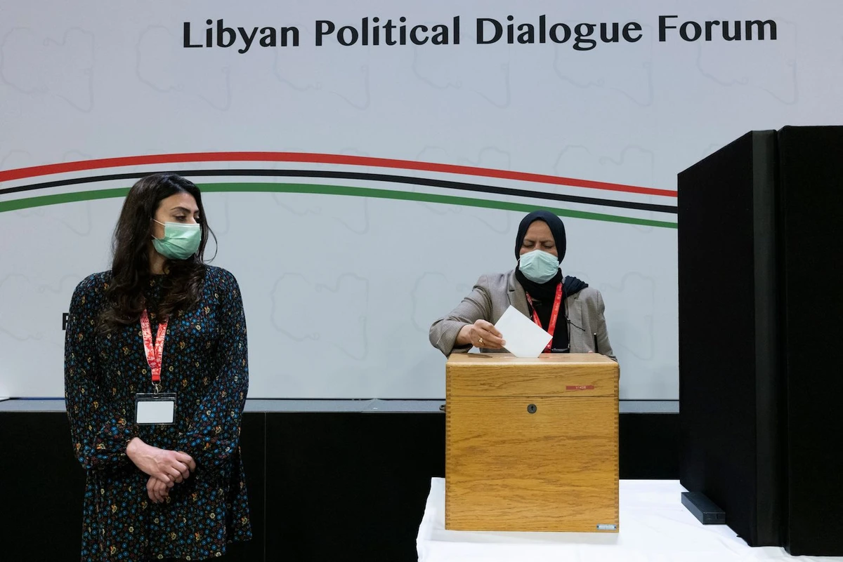 A delegate casts her vote for the new interim government during a meeting of the Libyan Political Dialogue Forum near Geneva. (File/AFP)
