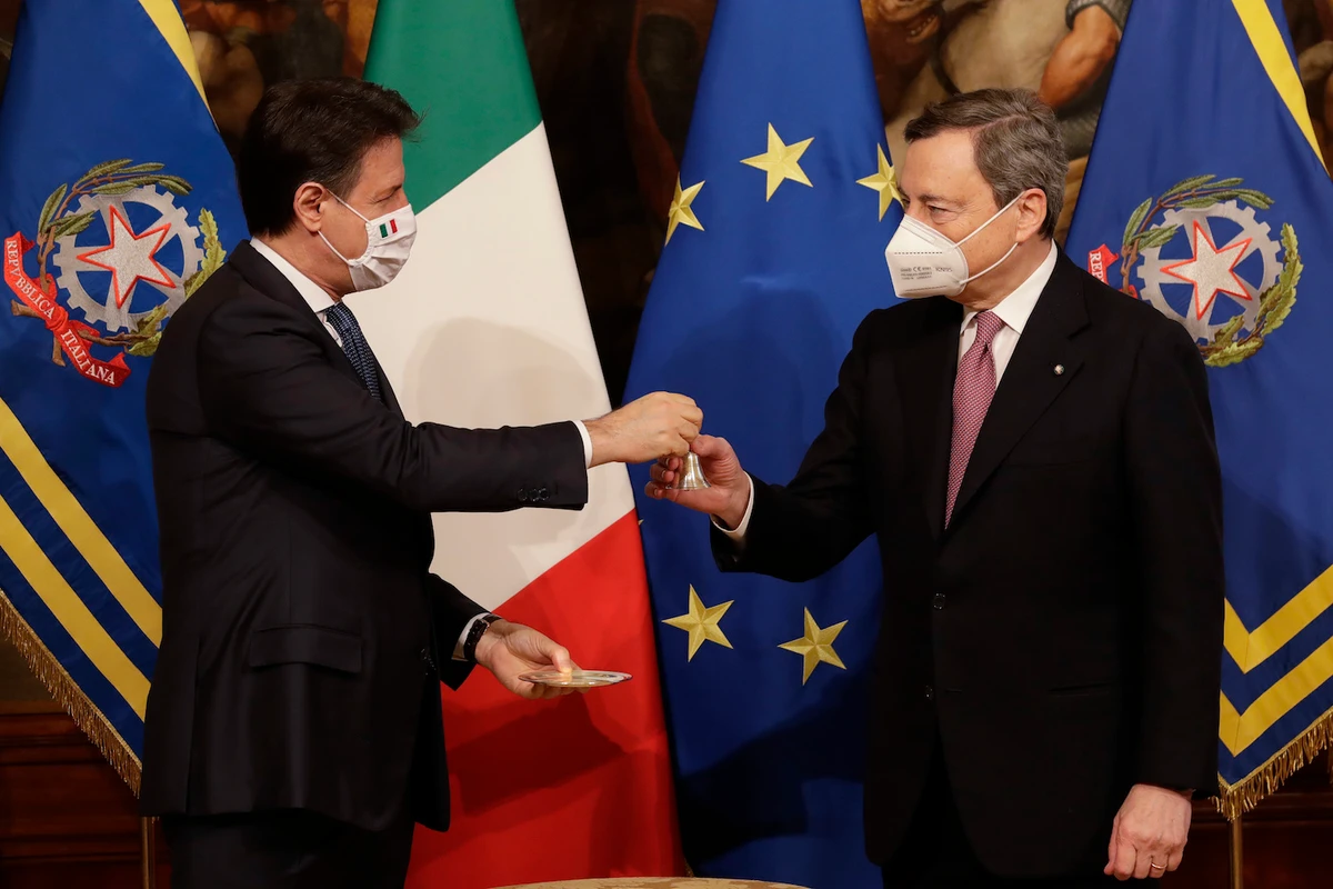 Italian outgoing Premier Giuseppe Conte hands over the cabinet minister bell to new Premier Mario Draghi, during the handover ceremony at Chigi Palace Premier's office, in Rome, Saturday, Feb. 13, 2021. (AP)