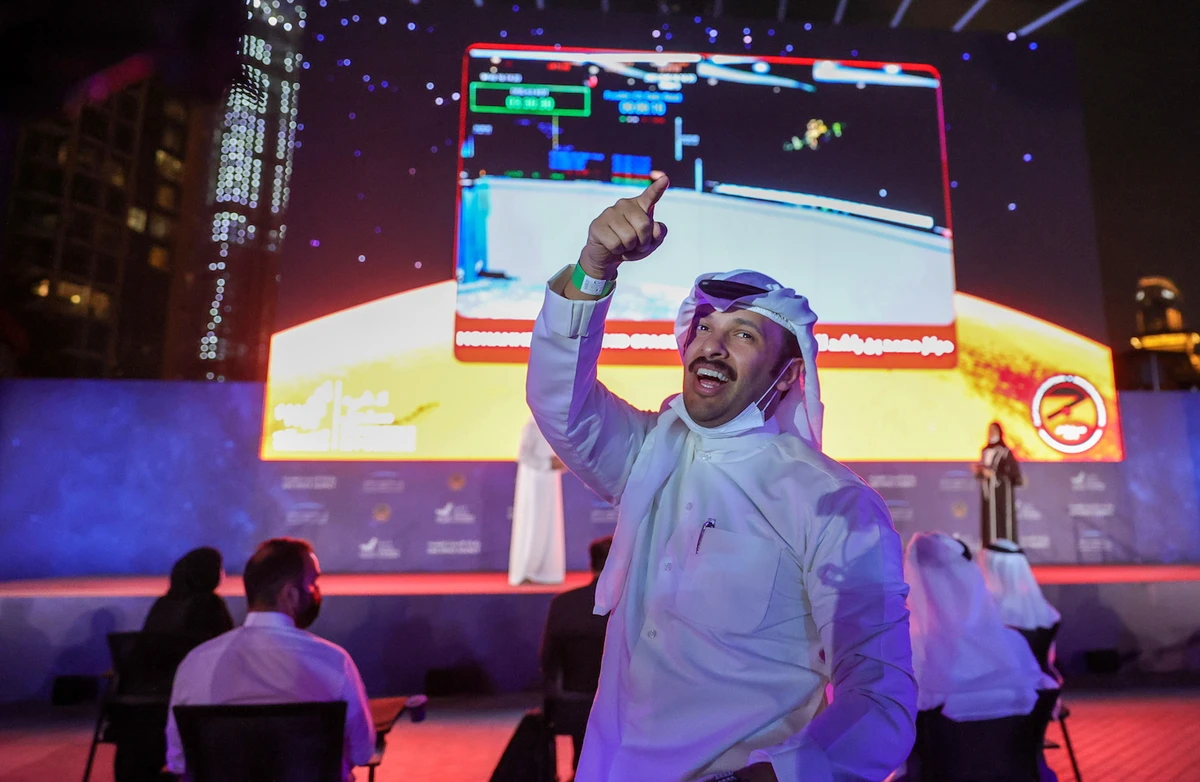 A man gestures as people watch a screen displaying information of the Hope Probe entering the orbit of Mars, in Dubai, UAE. (File/Reuters)
