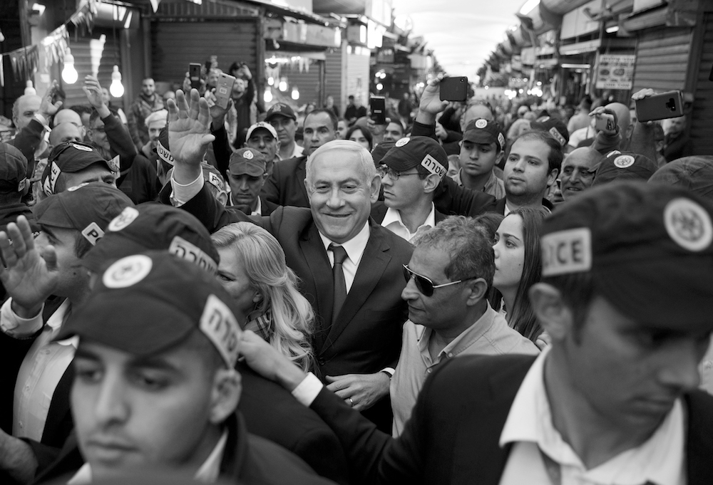 Israeli Prime Minister Benjamin Netanyahu is escorted by security guards during a visit to the Ha'tikva market in Tel Aviv, Israel, April 2, 2019. (AP Photo)