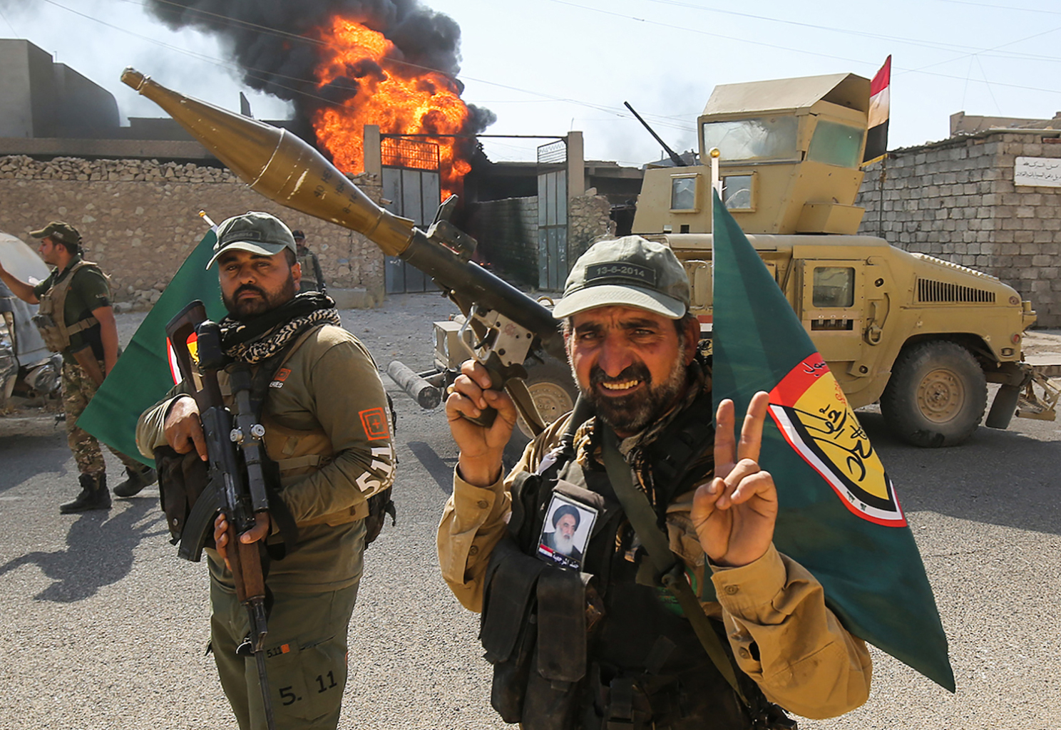 Popular Mobilization Unit fighters flash the victory sign as they advance through the streets of Tal Afar, west of Mosul, Aug. 26, 2017. (AFP)