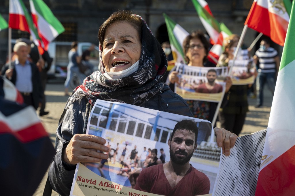 A woman holds a portrait of Iranian wrestler Navid Afkari during a demonstration in the Netherlands. (File/AFP)