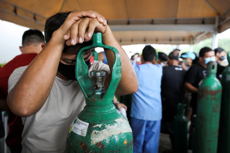 Relatives of patients hospitalised or receiving healthcare at home, who are mostly suffering from COVID-19, gather to buy oxygen and fill cylinders in Manaus, Brazil, Jan. 18, 2021. (Reuters)