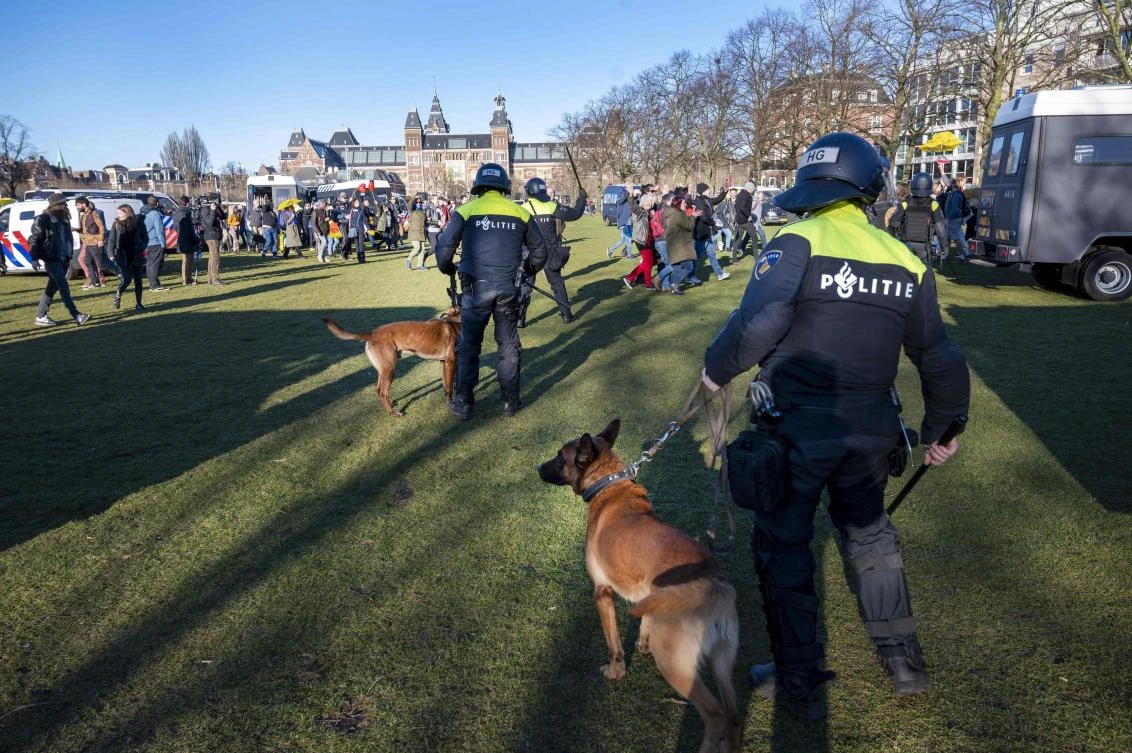 Policemen with dogs intervene during a demonstration against Covid-19 health guidelines, in the Museumplein square in Amsterdam, on February 28, 2021. (AFP)