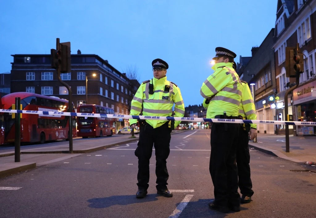 Officers guard a cordon at the junction of Woodbourne Road south London on Feb. 2, 2020, after a man was shot dead by police, following a suspected ‘terrorist-related’ incident earlier in the week. (AFP)