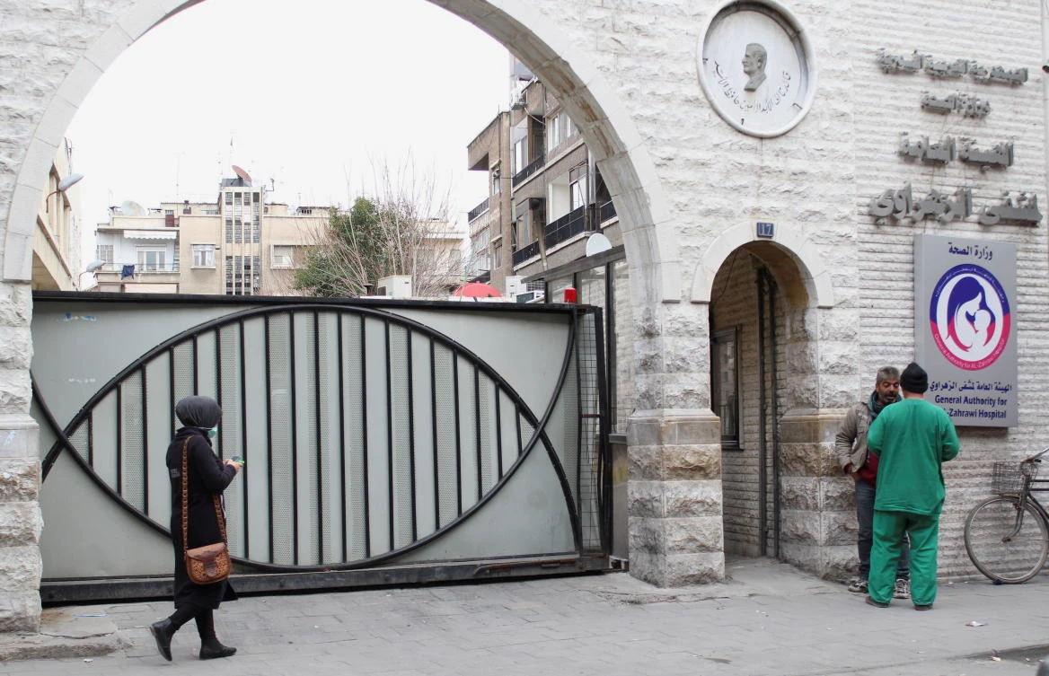 People stand outside a hospital in Damascus, Syria on March 3, 2021. (Reuters)