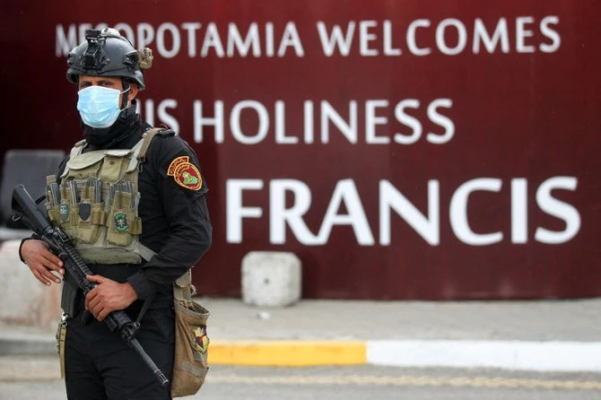 A member of the Iraqi special forces stands guard outside the Syriac Catholic Church of Our Lady of Deliverance, in front of a billboard welcoming Pope Francis, in the Iraqi capital Baghdad, on March 4, 2021. (AFP)