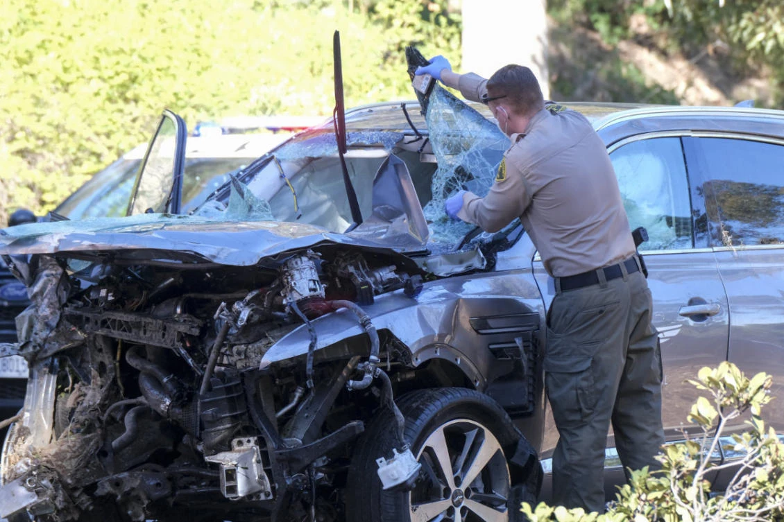 In this Feb. 23, 2021, file photo, a law enforcement officer looks over a damaged vehicle following a rollover accident involving golfer Tiger Woods in the Rancho Palos Verdes suburb of Los Angeles. (AP Photo/Ringo H.W. Chiu,File)