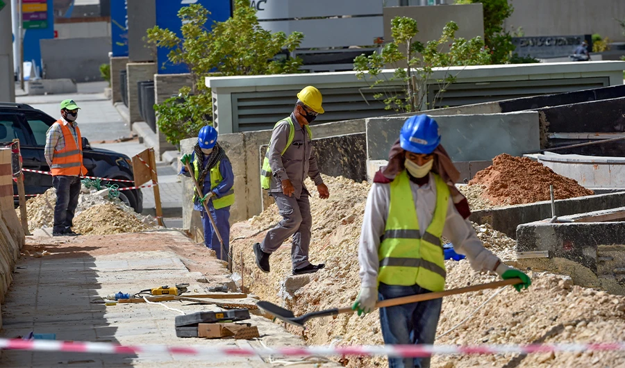 Workers wearing protective face masks work on a road in the Saudi capital Riyadh on June 21, 2020. (AFP)
