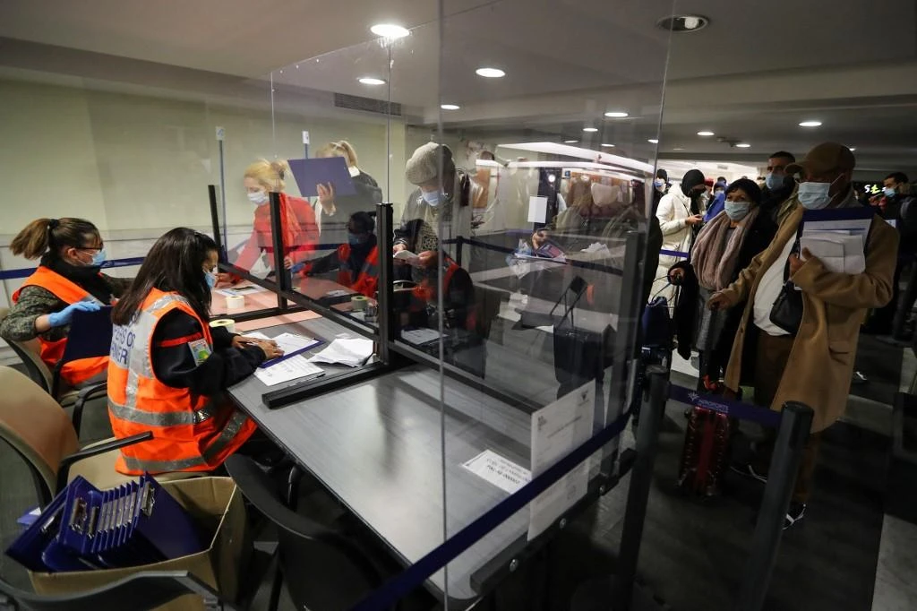 Above, airline passengers show their self-attested movement document to French civil security officials at Nice airport in southern France on Feb. 22, 2021. (AFP)