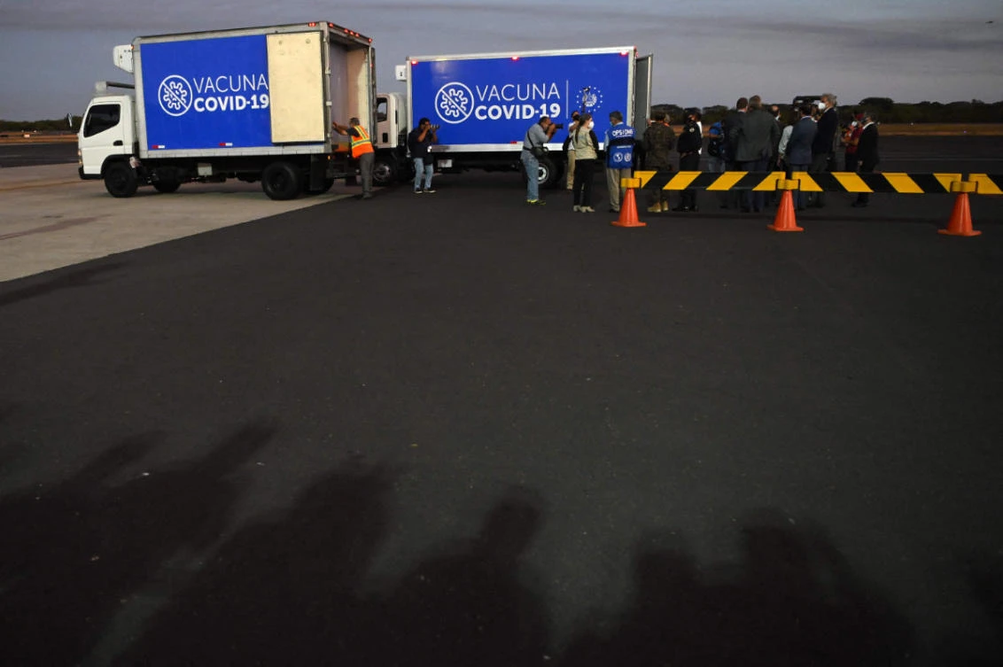 Trucks transport the second shipment of the AstraZeneca vaccine provided by the COVAX mechanism upon its arrival at San Oscar Romero International Airport in San Luis Talpa, El Salvador, on March 11, 2021. (AFP / MARVIN RECINOS)