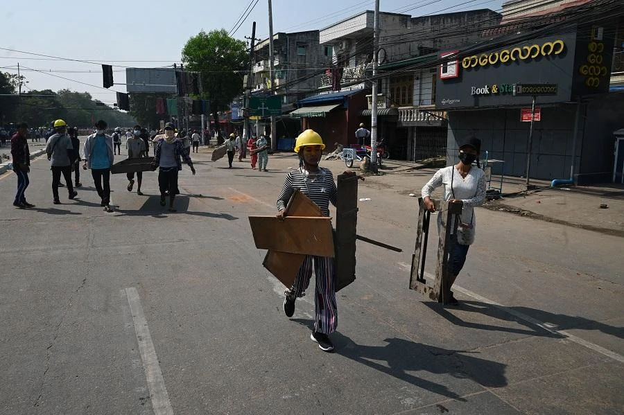 Protesters carry materials to build a barricade as they take part in a demonstration against the military coup in Yangon on March 11, 2021. (File/AFP)
