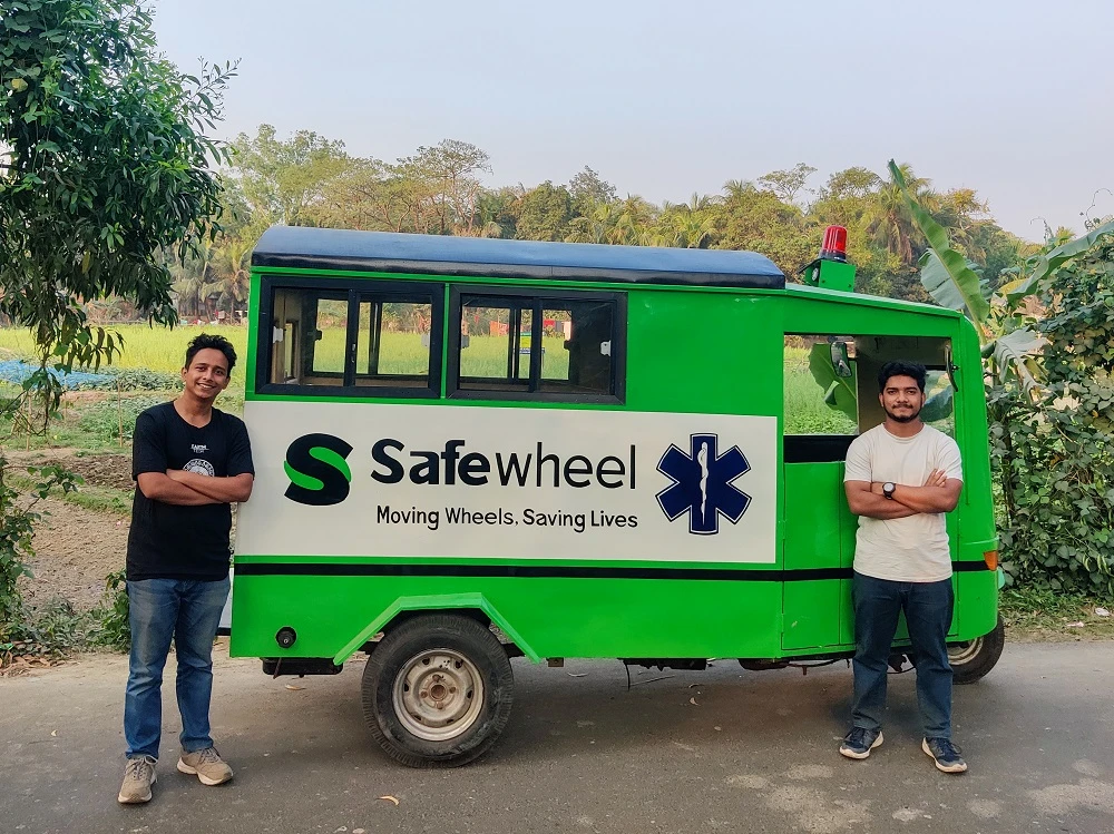 Safewheel co-founder Faysal Islam, left, stands next to a three-wheeler ambulance that provides emergency health services to the Feni district, Bangladesh. (Courtesy Safewheel)