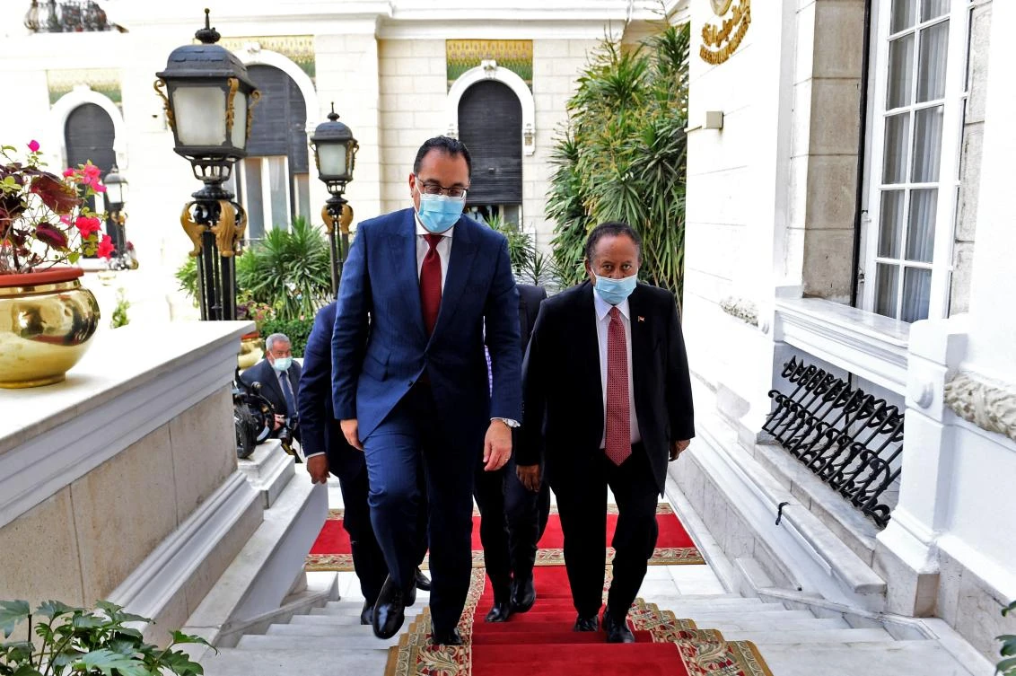 Egyptian Prime Minister Mostafa Madbouly (L) receives his Sudanese counterpart Abdalla Hamdok in the Egyptian capital Cairo, on March 11, 2021. (AFP)