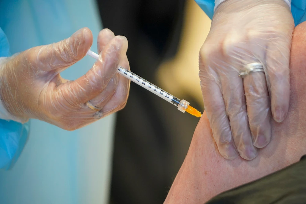A health worker administers a dose of the AstraZeneca vaccine against COVID-19 to a patient inside the convention center known as “La Nuvola,” The Cloud, in Rome. (File/AP)