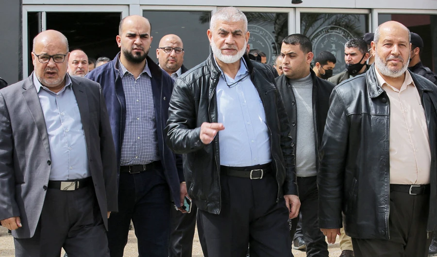 Hamas leaders Essam Aldalis (L) Ruwhi Mushtaha (C) Khalil Al-Hayya (R) walk outside the VIP hall at the Rafah border crossing with Egypt in the southern Gaza Strip on March 15, 2021 as they travel to Egypt for talks. (AFP)