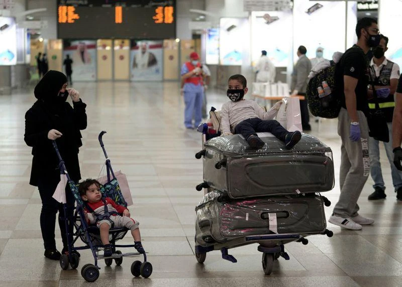 A Kuwaiti family repatriated from Amman, wearing protective face masks, prepare their luggage while arriving at Kuwait Airport, following the outbreak of the coronavirus disease (COVID-19), in Kuwait City, Kuwait April 21, 2020. (Reuters)