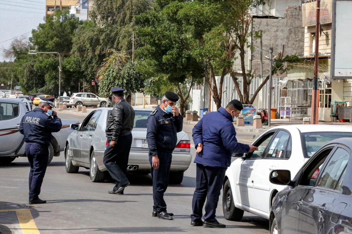 Police officers stop vehicles at a checkpoint in the Karrada district of Iraq's capital Baghdad on March 14, 2021, as they enforce a total curfew imposed to curb COVID-19 coronavirus cases. (AFP)