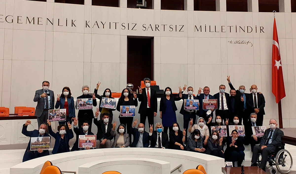 Omer Faruk Gergerlioglu, in front row-center with a blue mask, and his colleagues gesture after the parliament stripped his parliamentary seat, on Wednesday. (AP)