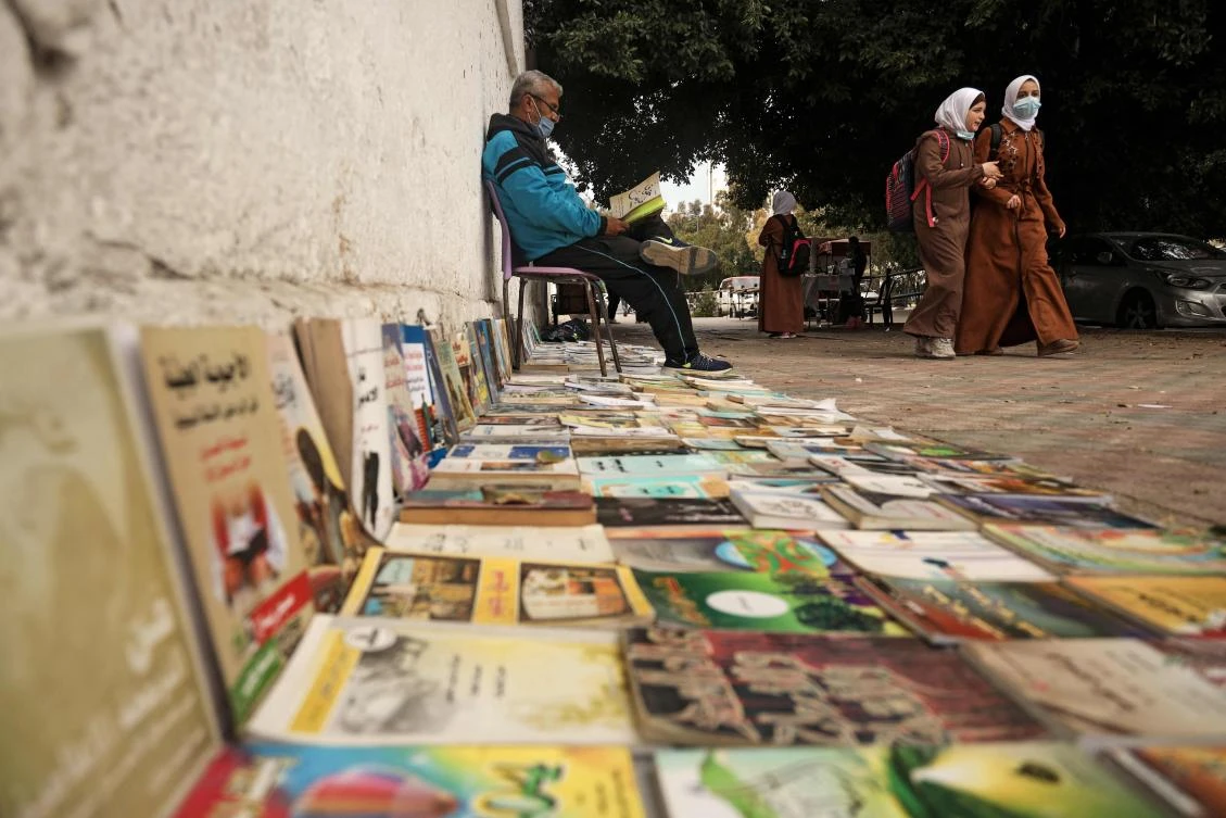 A Palestinian man reads a book as he waits for customers in Gaza City. The Palestine Investment Fund wants to improve infrastructure in the Palestinian Territories. (AFP)