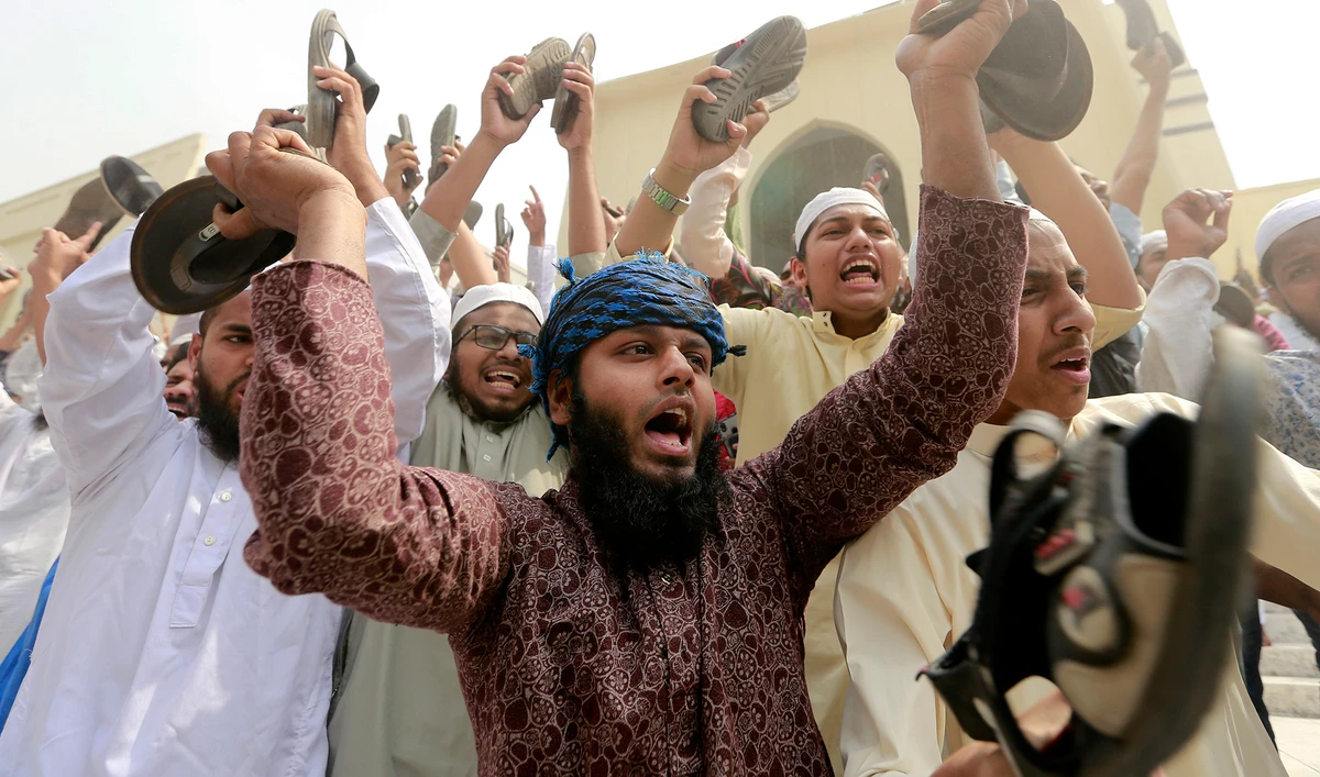 Bangladeshis raise their footwear and shout slogans during a protest after Friday prayers, against the visit of Indian Prime Minister Narendra Modi in Dhaka, Bangladesh, Friday, March 19, 2021. (AP)
