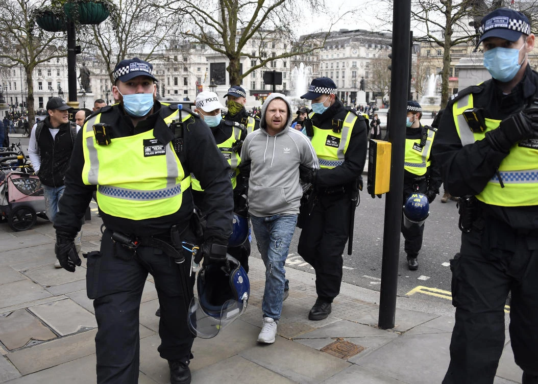 A man is arrested during a protest against government restrictions to curb the spread of the coronavirus in London on March 20, 2021. (AP Photo/Alberto Pezzali)