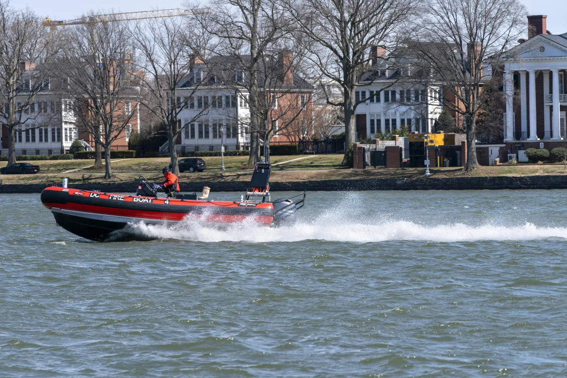 A District of Columbia Fire Boat checks buoys in the waterway next to Fort McNair, seen in background in Washington. (AP)