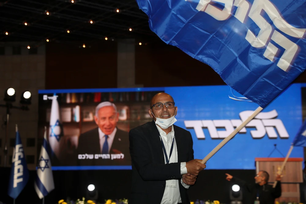Israeli Prime Minister Benjamin Netanyahu's supporters wave Likud party flags after first exit poll results for the Israeli elections at his party's headquarters in Jerusalem. (AP)