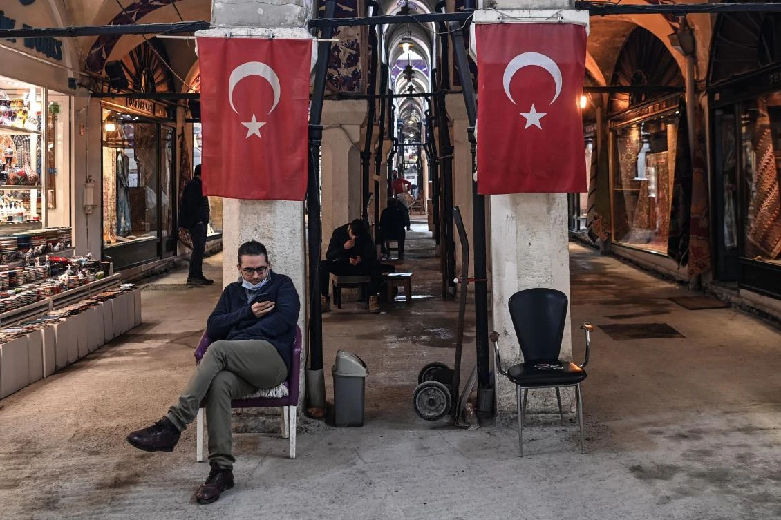 A shop owner studies his smartphone as he waits for customers inside The Grand Bazaar in Istanbul. (AFP)