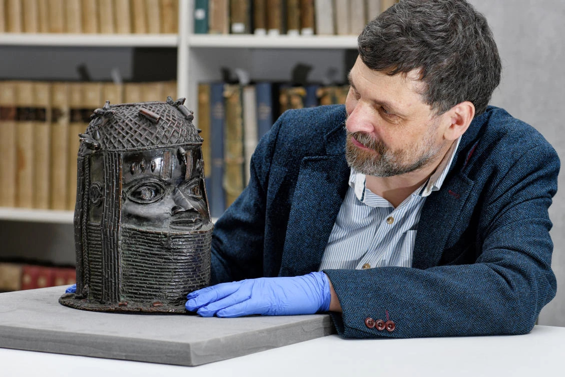 Neil Curtis, Head of Museums and Special collections, with one of the Benin bronze depicting the Oba of Benin at The Sir Duncan Rice Library, the University of Aberdeen in Scotland. (University of Aberdeen via Reuters)