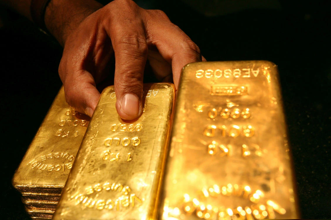 A security guard places several one kilo gold bars inside a secured vault in Dubai. (Reuters)