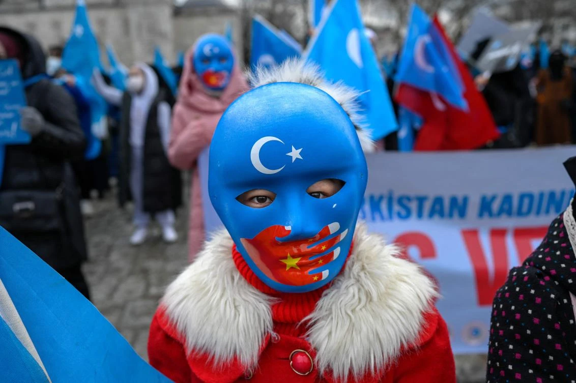A child from the Uyghur community living in Turkey wears a mask during a protest against the visit of China’s Foreign Minister to Turkey, Istanbul, March 25, 2021. (AFP)