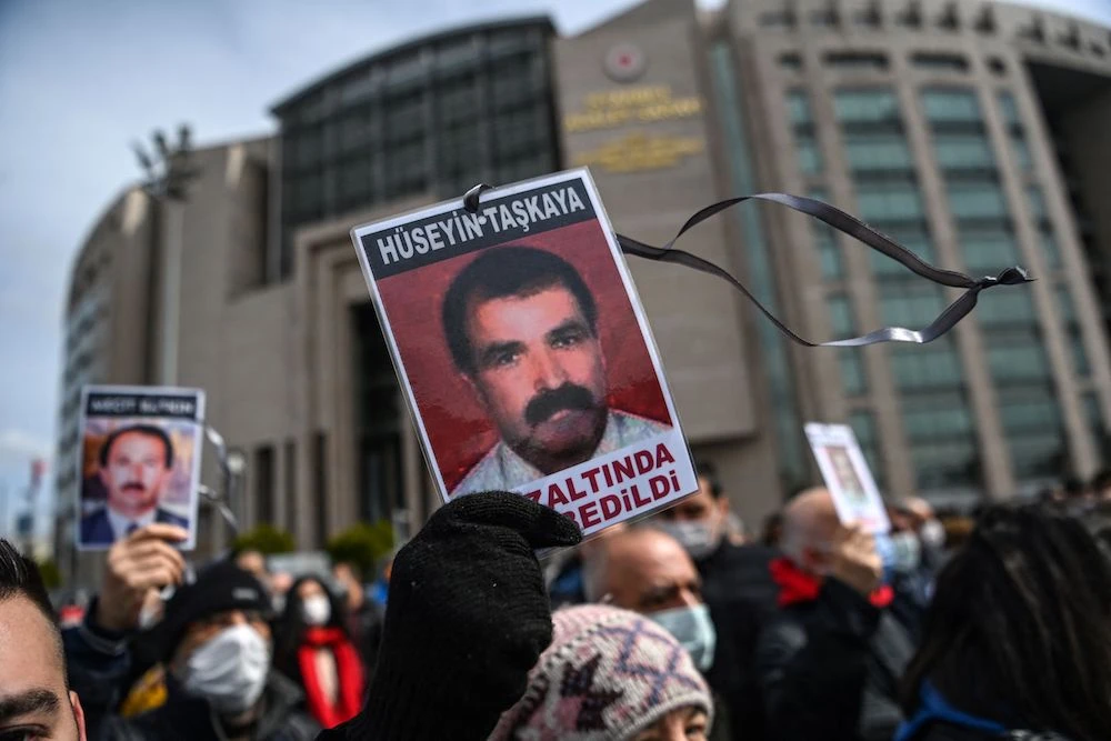 Members of the Saturday Mothers hold pictures of disappeared relatives in front of Caglayan courthouse, before their trial in Istanbul, March 25, 2021. (AFP)