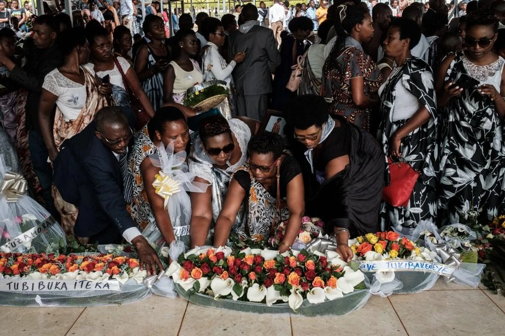 Attendees offer flowers after the burial of 81 coffins containing newly discoverd remains of 84,437 victims of the 1994 genocide during a funeral ceremony at the Nyanza Genocide Memorial, suburb of the capital Kigali, on May 4, 2019. (File/AFP)