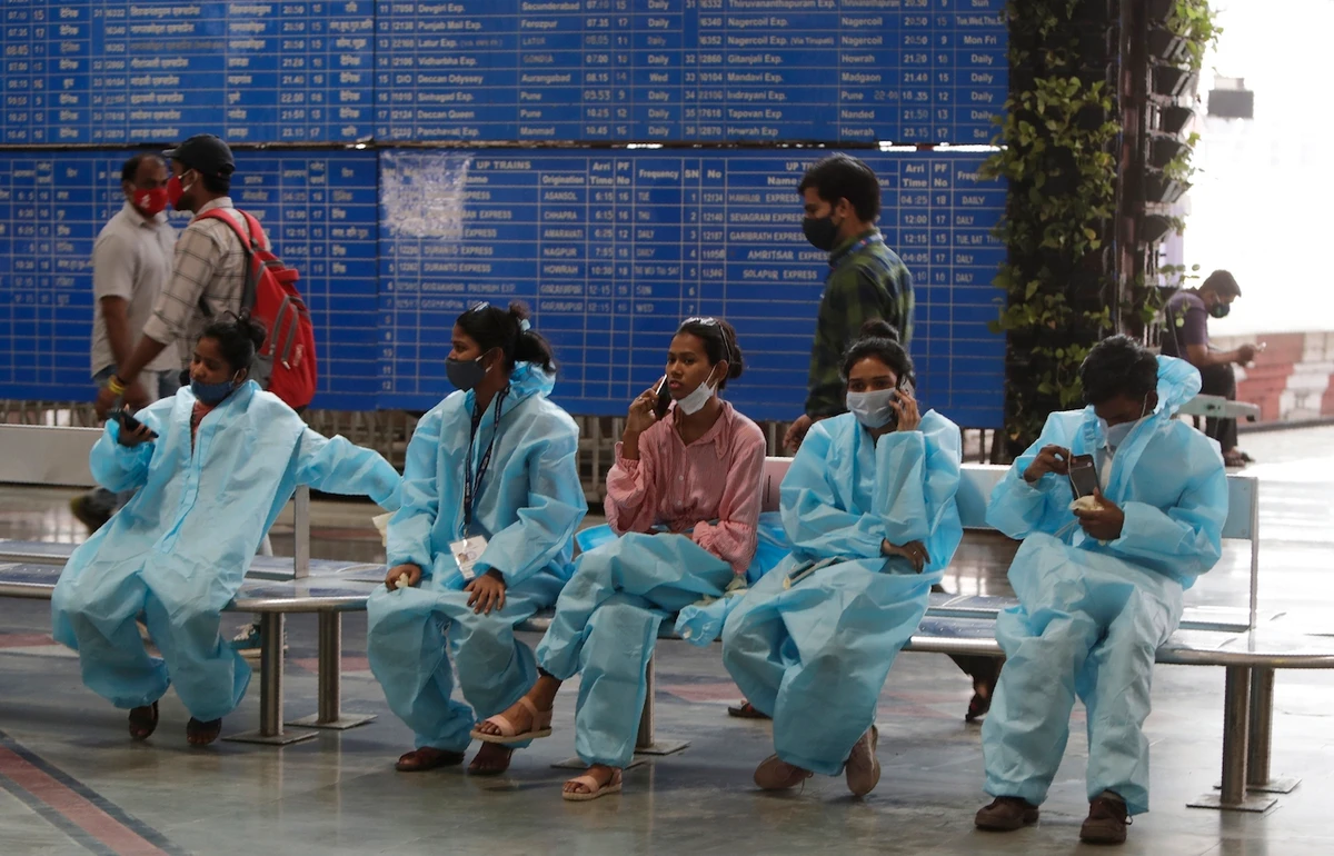 Health workers wait to conduct COVID-19 tests on passengers at Chhatrapati Shivaji Maharaj Terminus in Mumbai, India, Thursday, March 25, 2021. (AP)