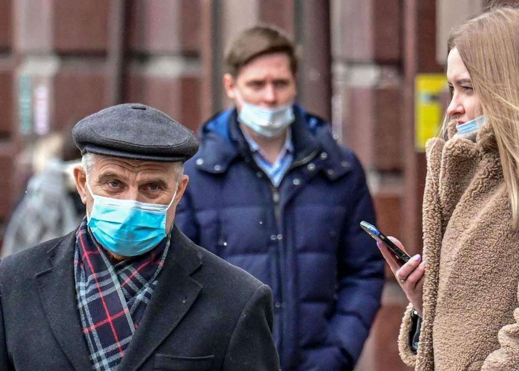 People wearing face masks walk along a street in central Moscow on March 25, 2021. (AFP)