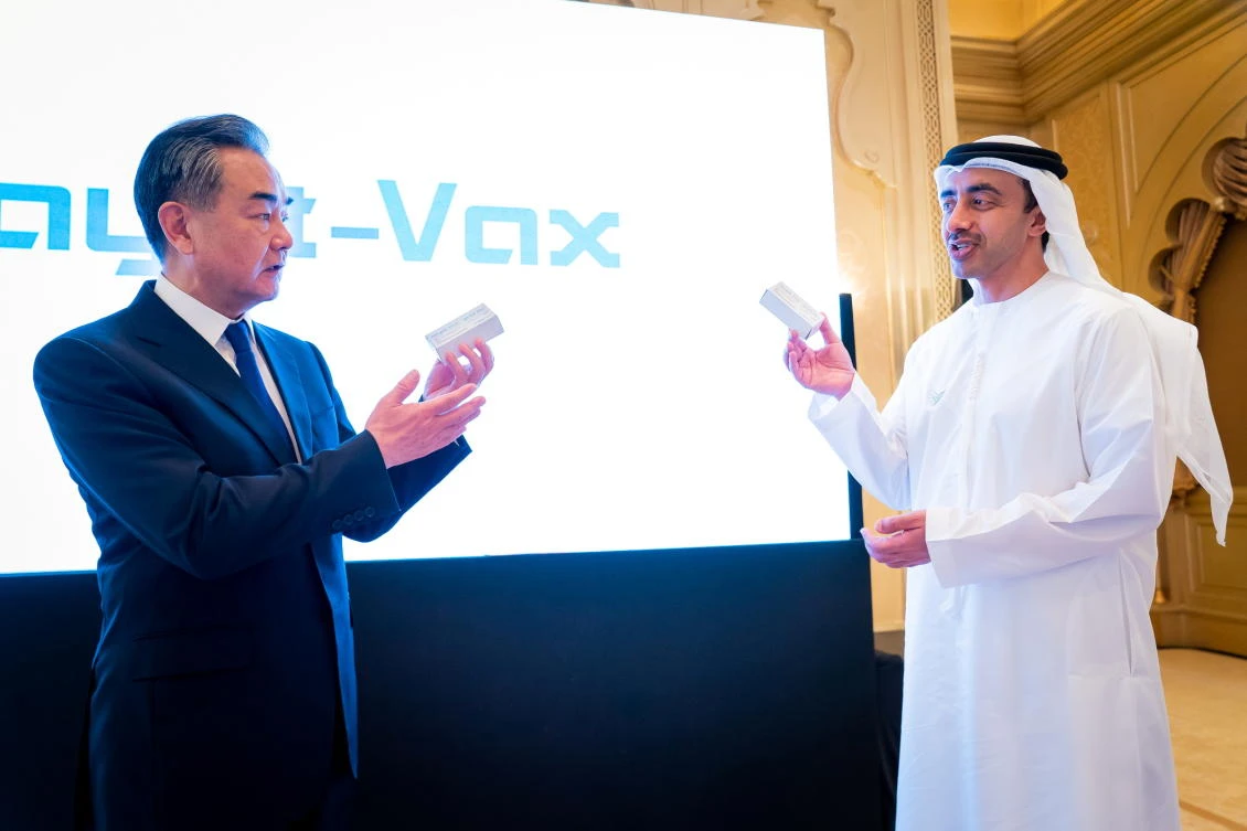 China’s State Councilor and Foreign Minister Wang Yi and UAE’s Foreign Minister Abdullah Bin Zayed Al Nahyan show the Chines made Coronavirus (COVID-19) vaccine Sinopharm during their meeting in Abu Dhabi, March 28, 2021. (WAM)