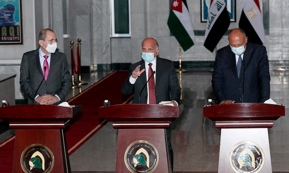 Iraqi Foreign Minister Fuad Hussein (C) speaks accompanied by Egypt’s Foreign Minister Sameh Shoukry (R) and Jordan’s Foreign Minister Ayman Safadi (L) during a joint news conference after their meeting in Baghdad, Iraq, Monday, March 29, 2021. (AP)